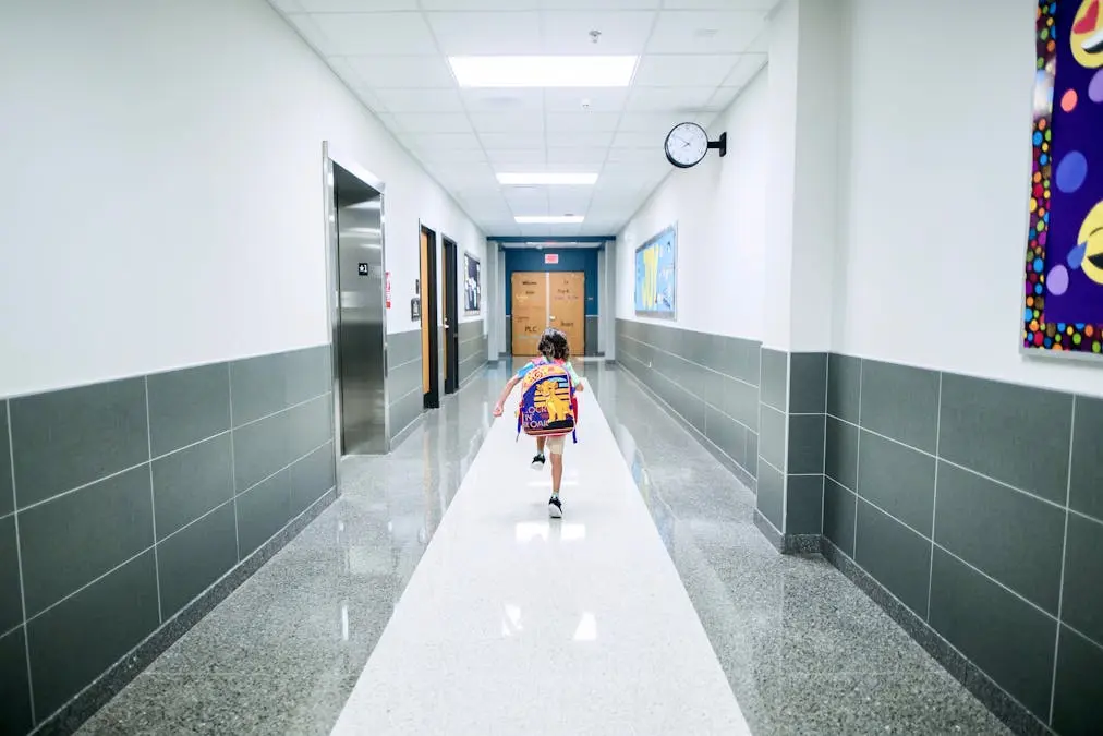 Couloir d'établissement scolaire avec signalisation de sortie