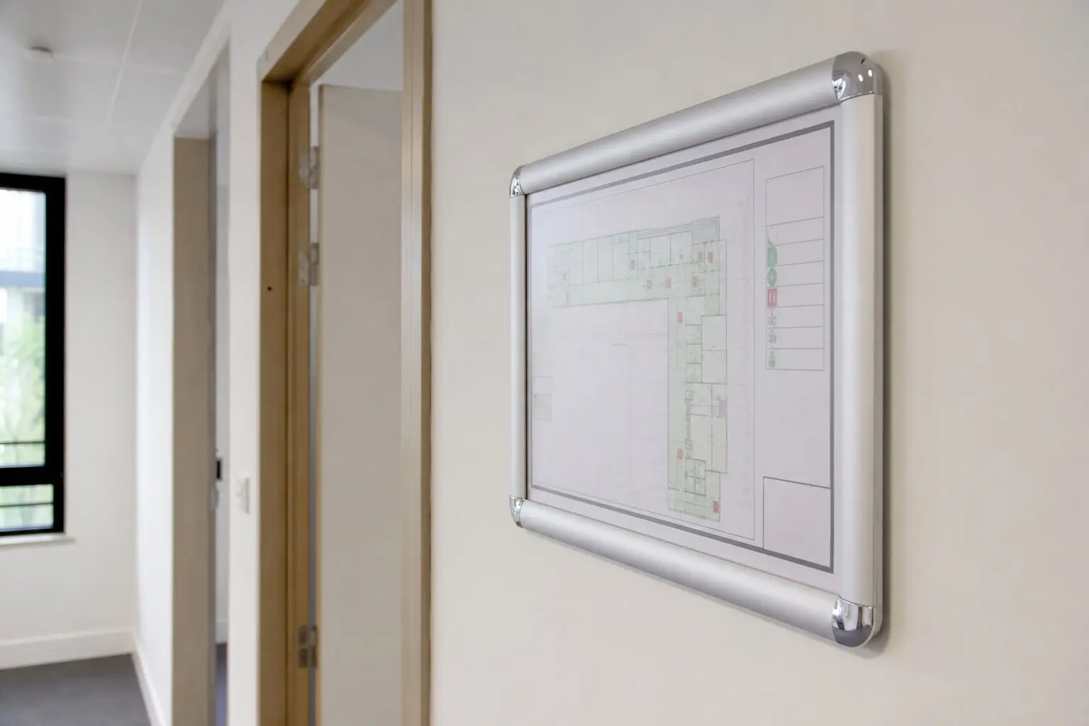 Plan d'évacuation affiché dans un couloir de bâtiment tertiaire